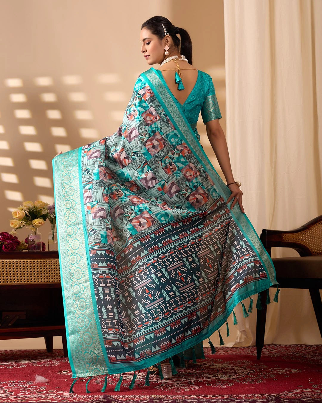 Woman wearing a traditional saree with a floral pattern in a room setting
